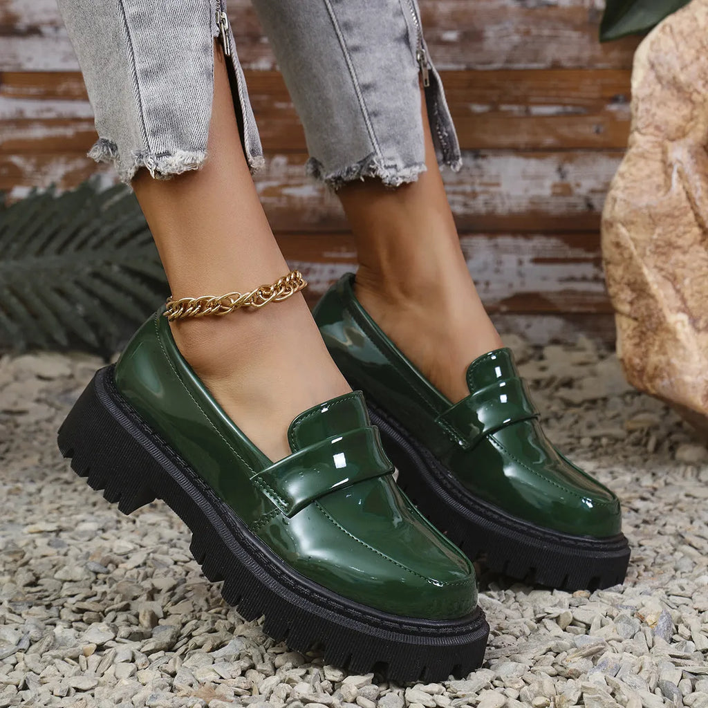 Women's plus size black slip-on loafers with a chunky platform heel and rubber sole.