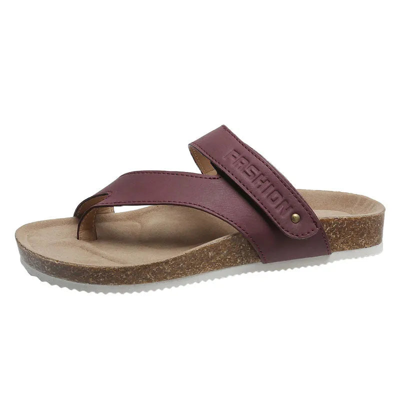 Flat toe ring flip-flops in blue with a thick foam sole on a wooden floor.