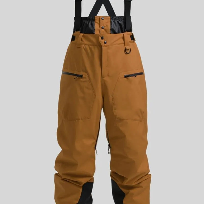 Man wearing black waterproof ski trousers with an adjustable strap, on a ski slope.
