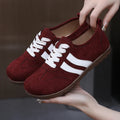 Women's vintage-style sneakers in dark red with a canvas upper and round toe.