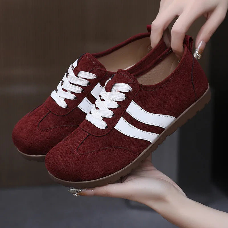 Women's vintage-style sneakers in dark red with a canvas upper and round toe.