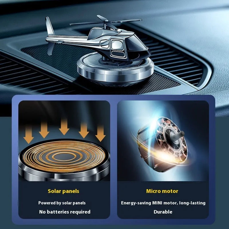 Silver metal solar helicopter car air freshener ornament with rotating blades on dashboard