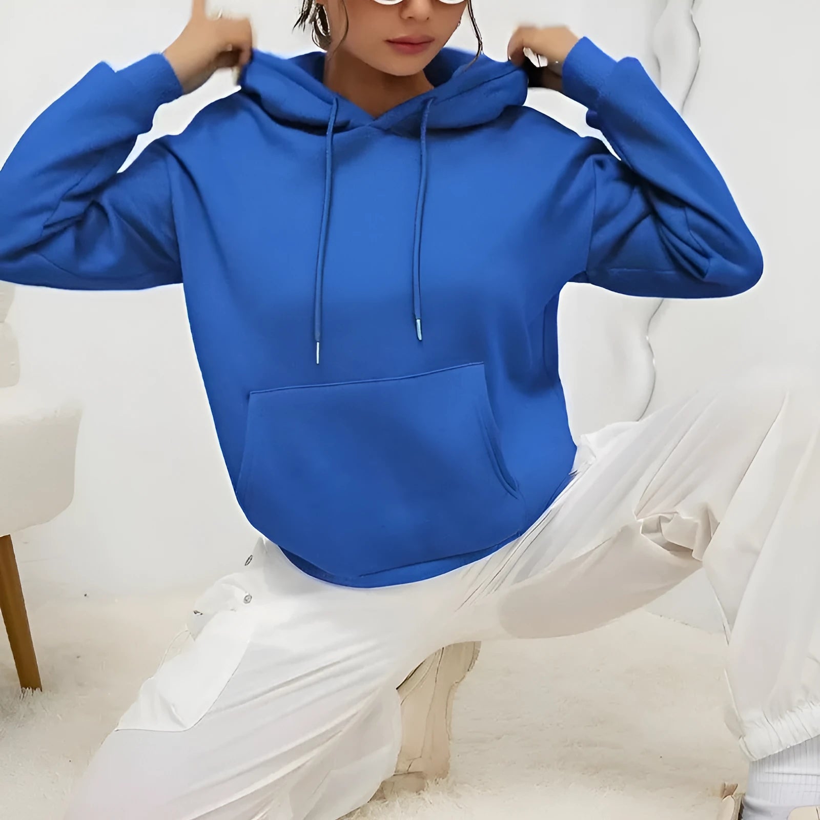 Women's loose drawstring pocket sweatshirt in polyester fabric showing side pockets and long sleeves