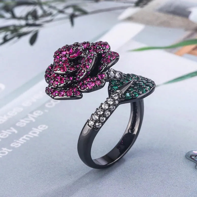 Gold-plated copper women's ring with geometric flower design and simulated red corundum in black gold colour.