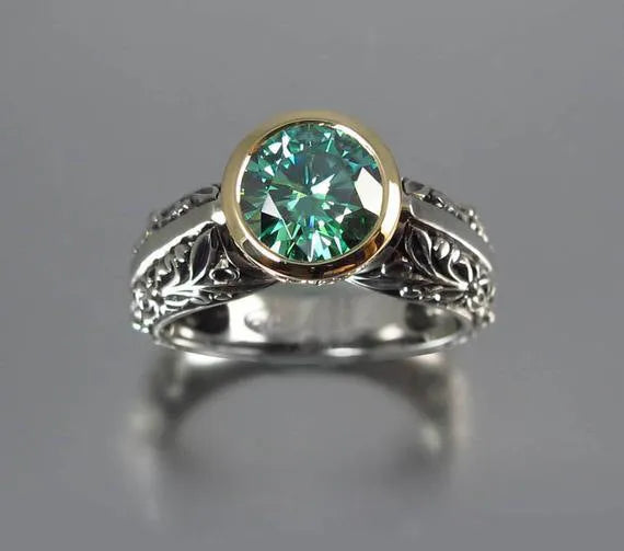 Flower-shaped vintage ring with gold-plated details and a green gemstone on a silver-toned alloy band.