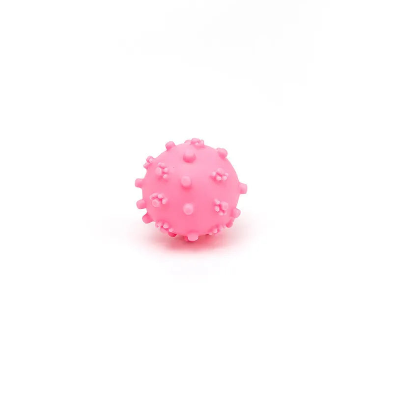 Set of four brightly coloured spiked squeaky dog balls on a blue background