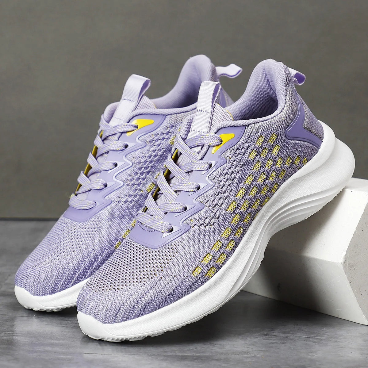 Women's lavender purple and blue Flyknit running shoes with mesh lining and striped pattern.