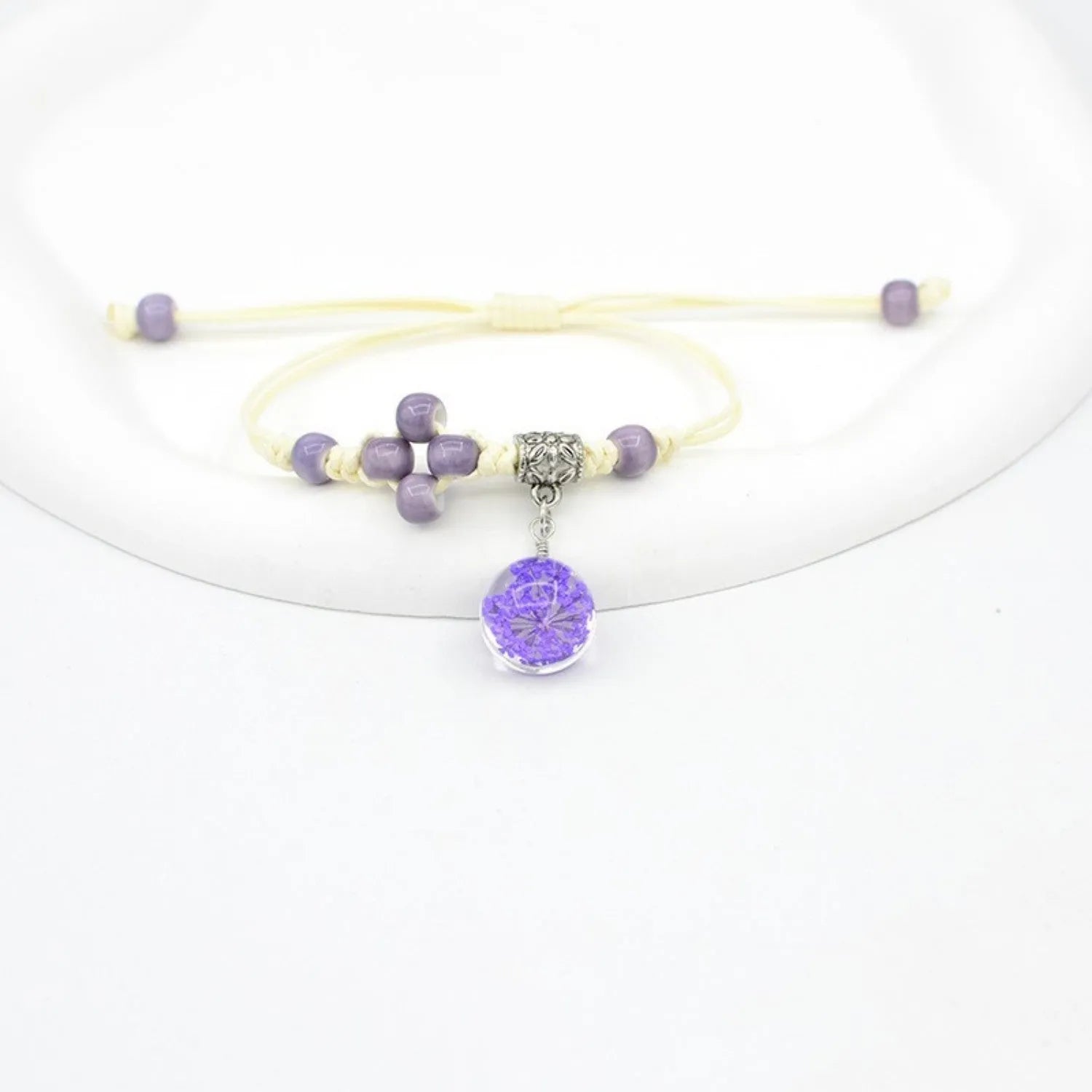 Women's hand-woven glass bracelet with large 1.4cm beads containing dried flowers, shown in blue colour option