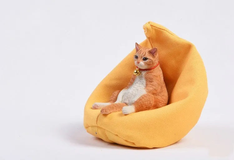 Small resin ornament of a cat sleeping on a sofa for car dashboard or shelf decoration.