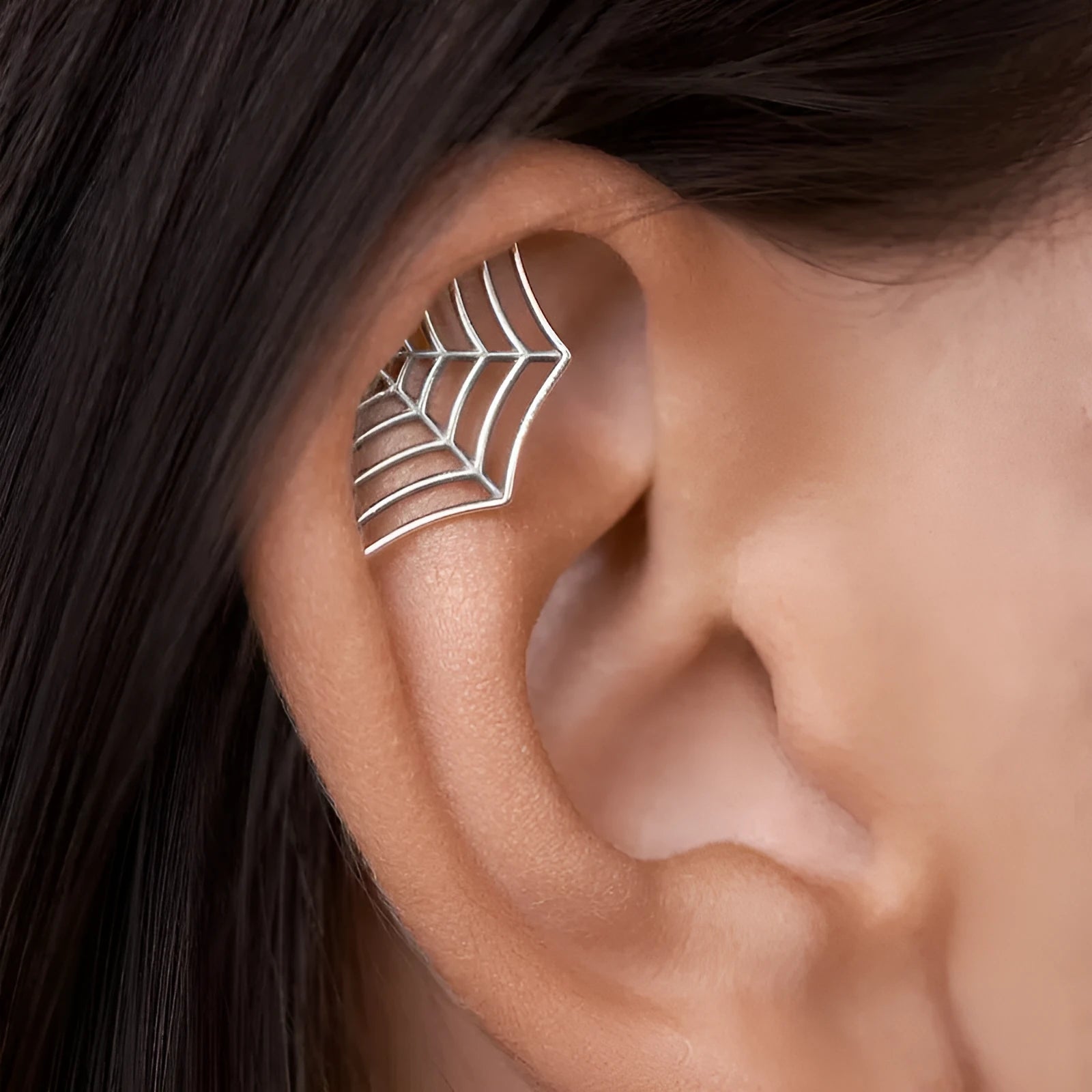 Geometric spider web design stud earrings in gold and silver electroplated metal.