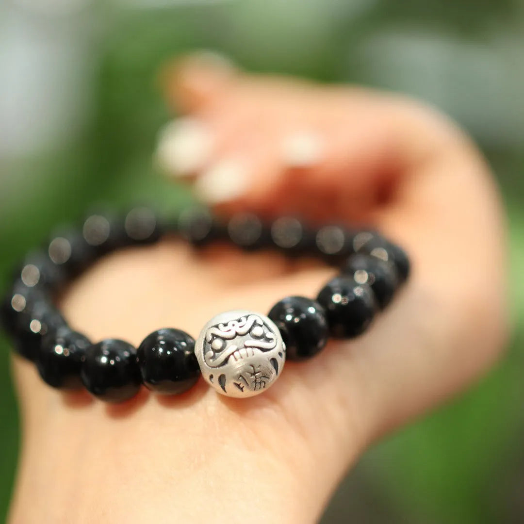 Close-up of a black agate and sterling silver bracelet showing 10mm beads and detailed clasp.