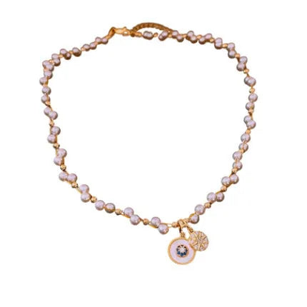 Gold electroplated women's necklace with round zircon and imitation pearl pendant on an adjustable clavicle chain.