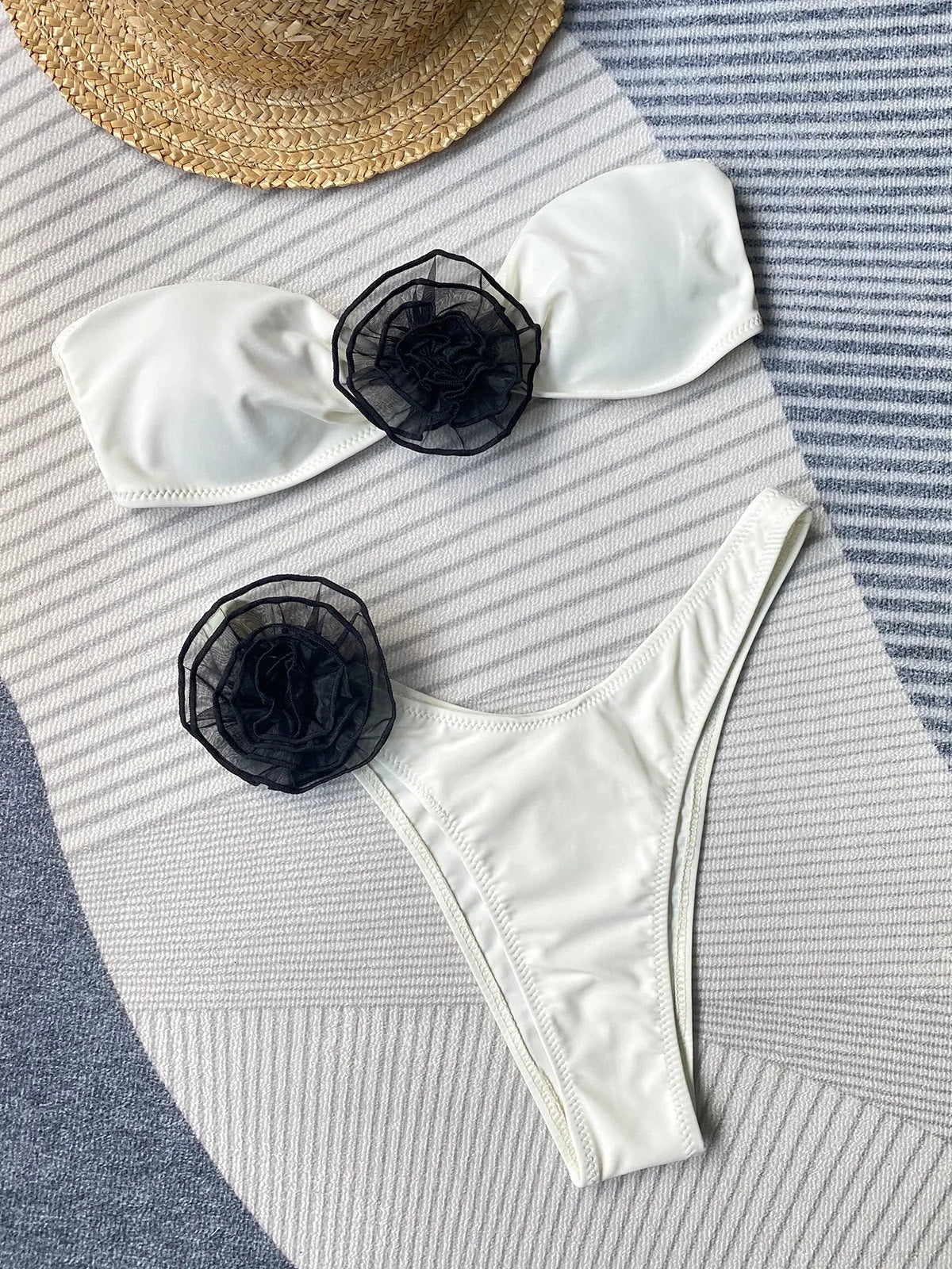 Black bikini with cross-back tube top and high-split shorts featuring three-dimensional floral details