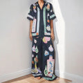 Women's black casual matching set with cartoon animation print, featuring a cardigan sleeve top and trousers