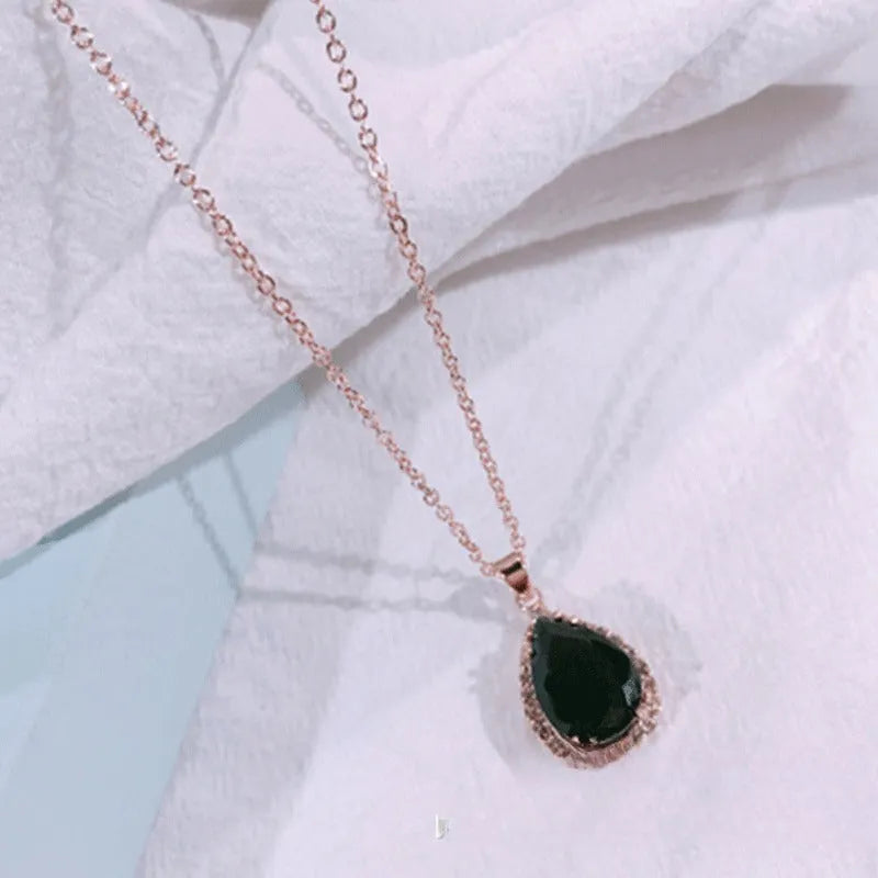 Water drop shaped pendant necklace with geometric design and rhinestone accents in pink colour
