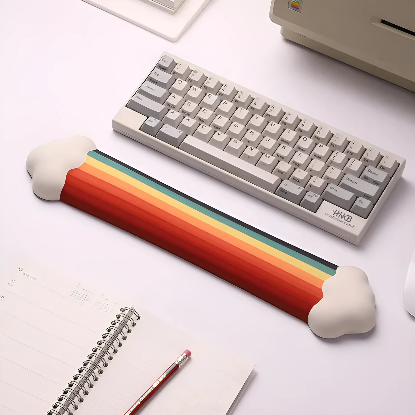 Silicone wrister mouse pad and keyboard support set with printed white cloud pattern on a desk.