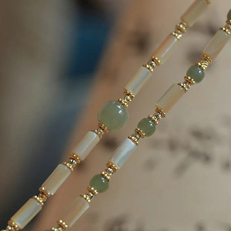 Simple geometric white Hetian jade bead bracelet for women on a wrist.
