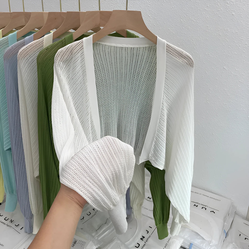 Women's white blouse with long, loose lantern sleeves featuring hollow-out details.