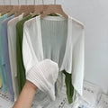 Women's white blouse with long, loose lantern sleeves featuring hollow-out details.