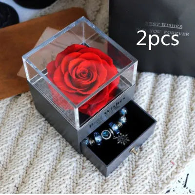 Glass eternal flower jewellery box with preserved roses and carnations inside measuring 8.5cm square