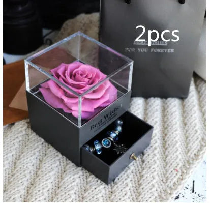 Glass eternal flower jewellery box with preserved roses and carnations inside measuring 8.5cm square