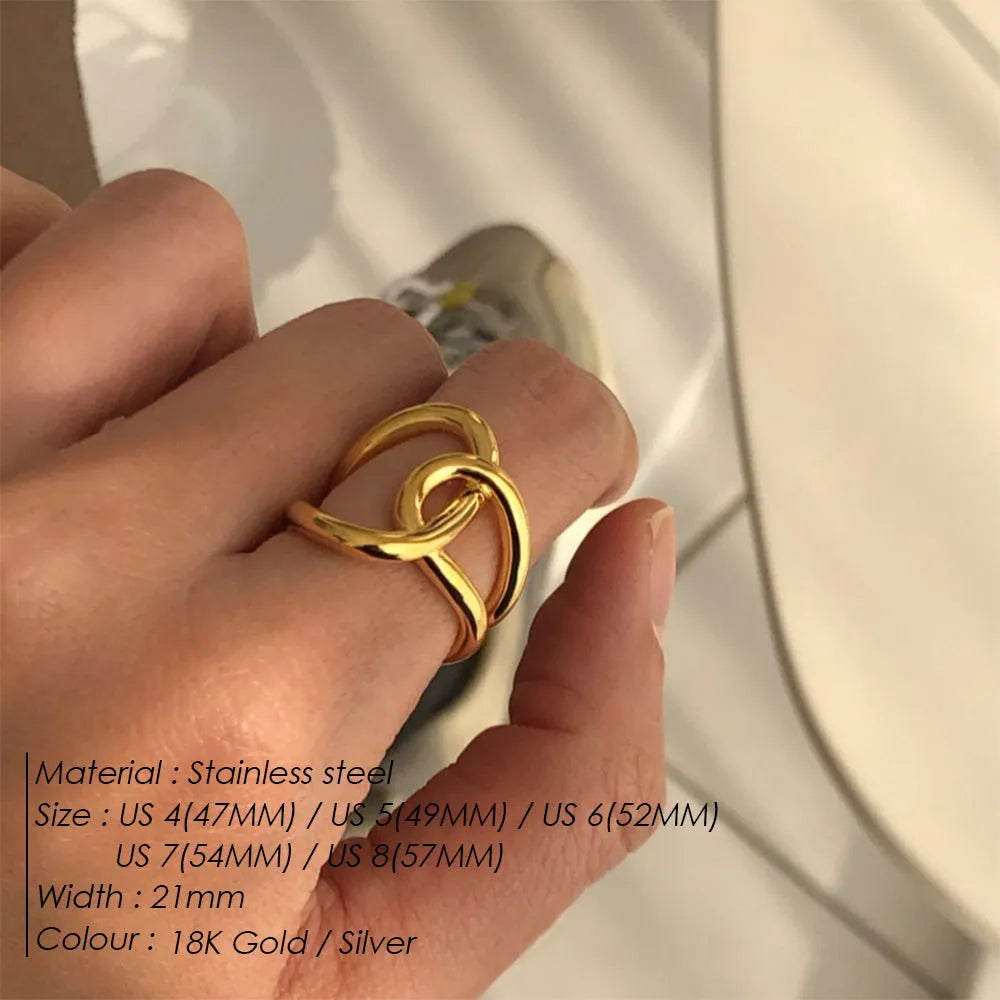 Geometric knotted U-shaped adjustable ring in stainless steel, shown in gold tone and steel colour.