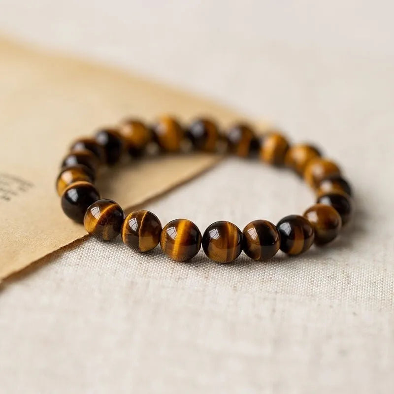 Tigereye stone bead bracelet with a single central Dzi bead featuring a circle design.