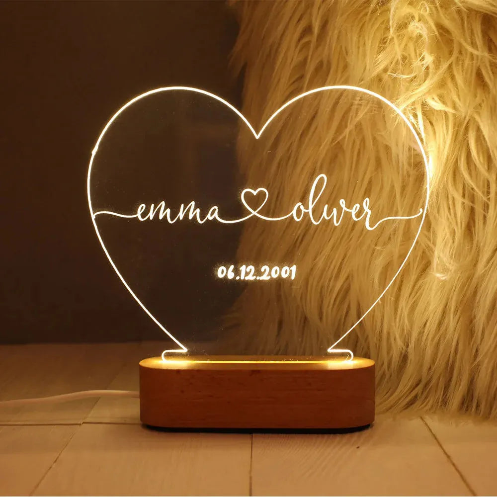 Personalised acrylic night light showing illuminated custom names and date on a transparent panel.