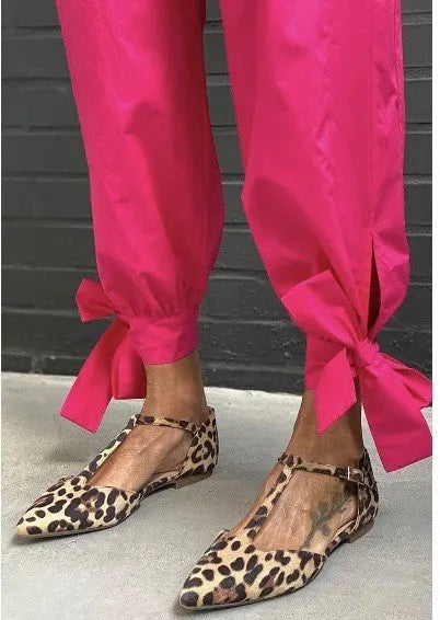 Leopard print women's pumps with pointed toe, chunky low heel, and cross shoulder straps.