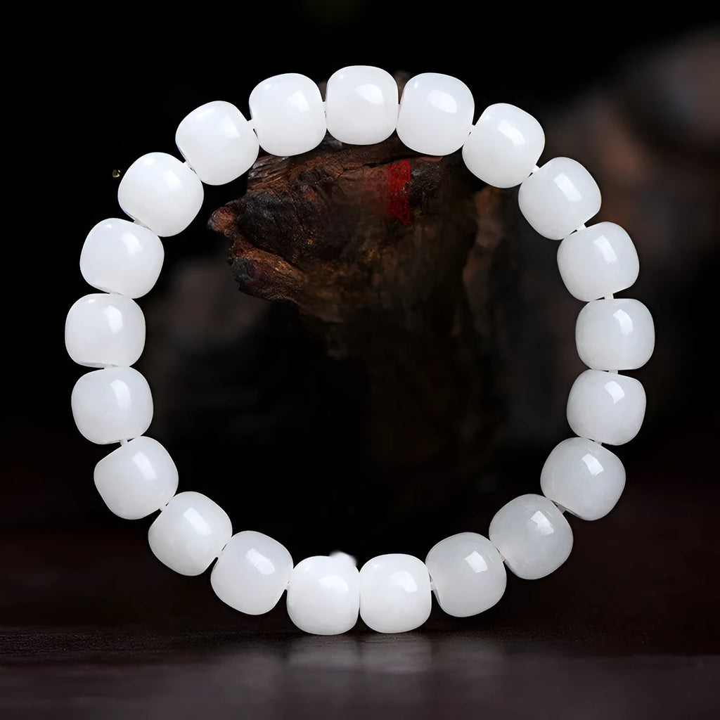 White Hetian jade barrel bead bracelet for men and women on a neutral background.