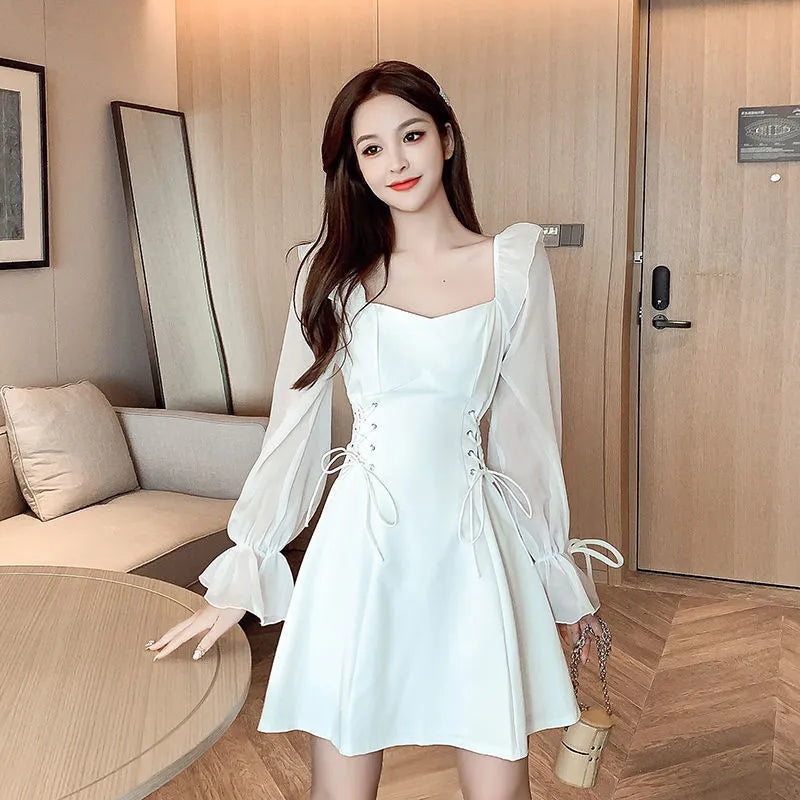 White chiffon patchwork dress on model, showing long sleeves and a long, slim-fitting skirt.