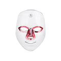 White rechargeable LED beauty mask with touch controls and adjustable head strap on a table.