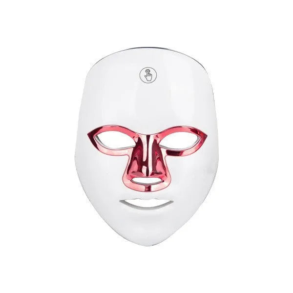 White rechargeable LED beauty mask with touch controls and adjustable head strap on a table.