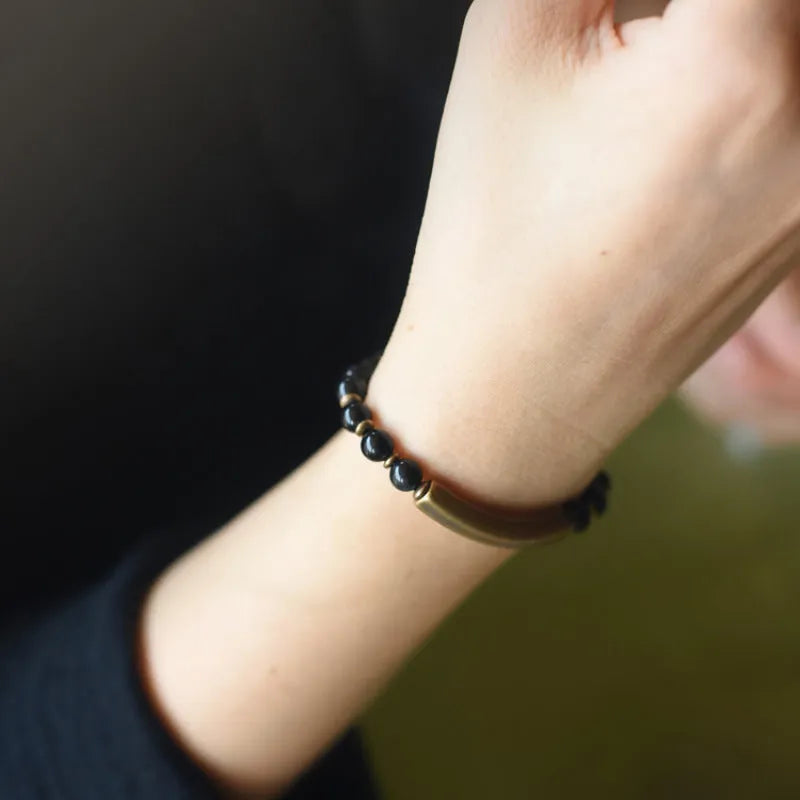 Layered unisex bracelet with water plants agate, red jasper, and obsidian stones on a wrist.