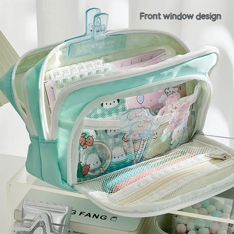 Double layer zippered pencil case in blue with a gift handle, shown next to pens and pencils.