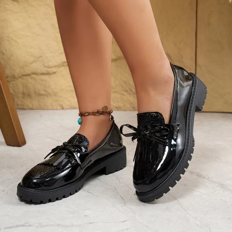 Women's black loafers with a decorative bow on the toe, made from synthetic PU material.