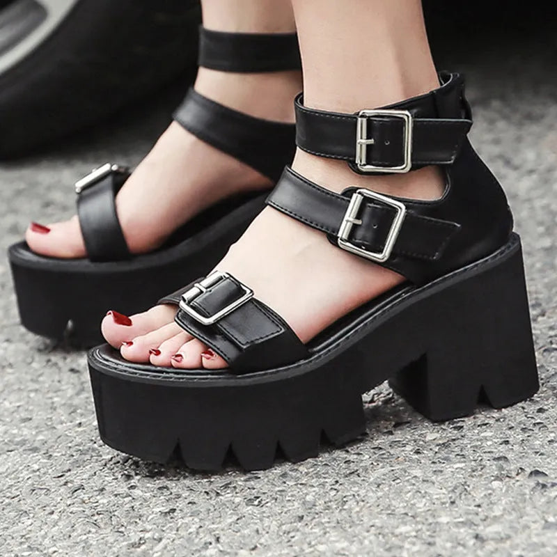 Black women's punk style platform sandals with chunky heel, buckle detail, and back zipper.