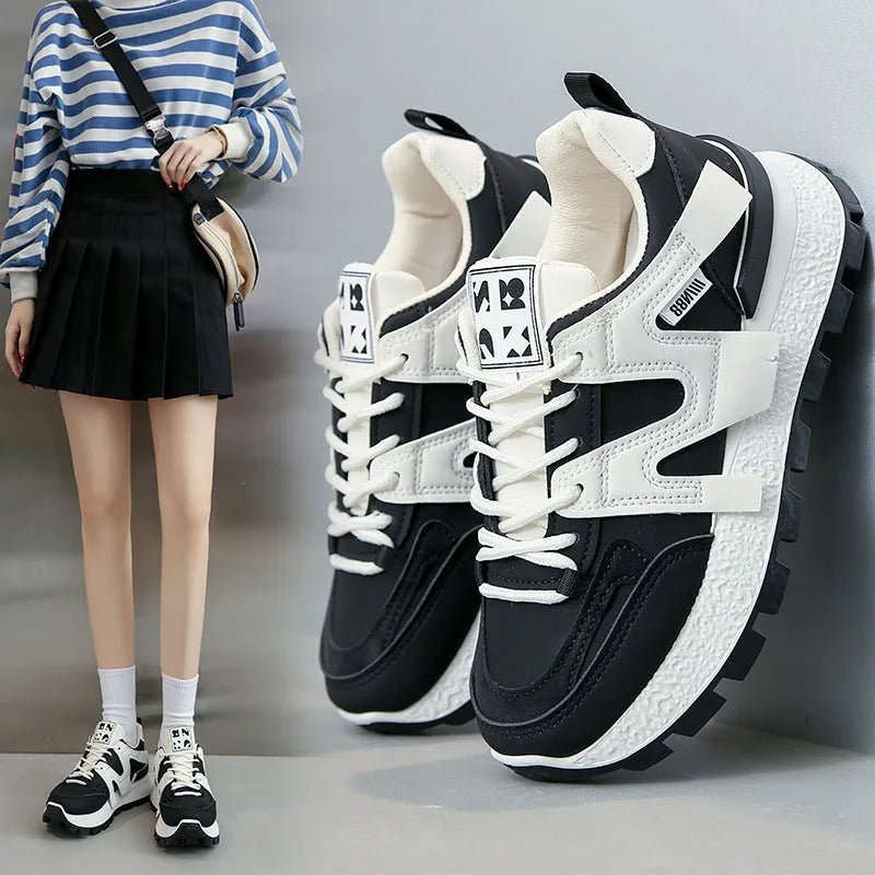 Pair of low-top unisex casual sneakers in black or white with round toe and front lace-up closure.