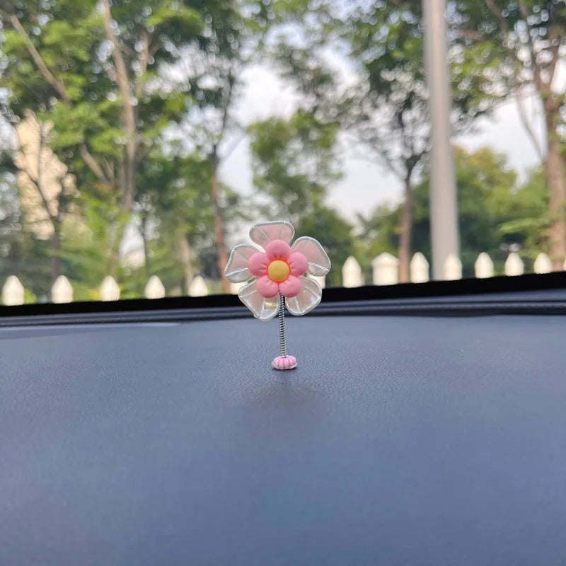 Small colourful plastic swing car decoration in blue, green, pink, purple, and yellow options.