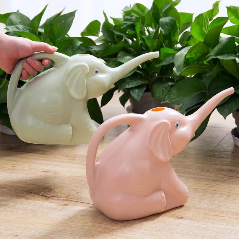 Pink baby elephant-shaped watering can with a long spout and baby bottle handle on a table.