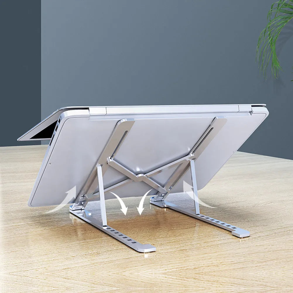Aluminum alloy laptop stand in silver colour, folded to show its slim profile next to a 15-inch laptop.
