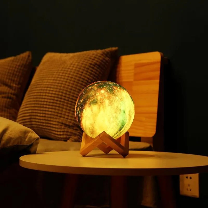 White spherical lunar night light with textured surface and soft LED glow on a dark surface.
