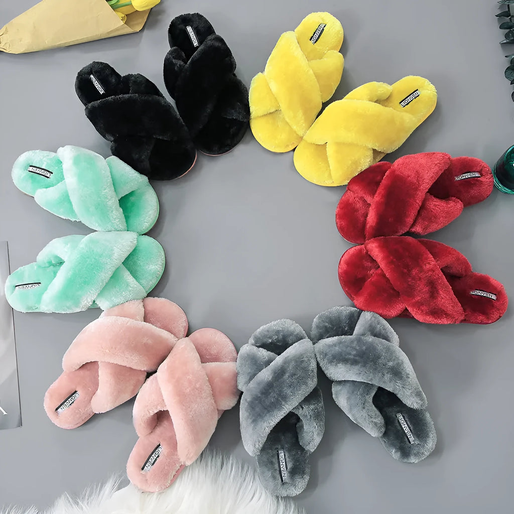 Women's black cross-strap open-toe fur slippers showing the patterned non-slip rubber sole.