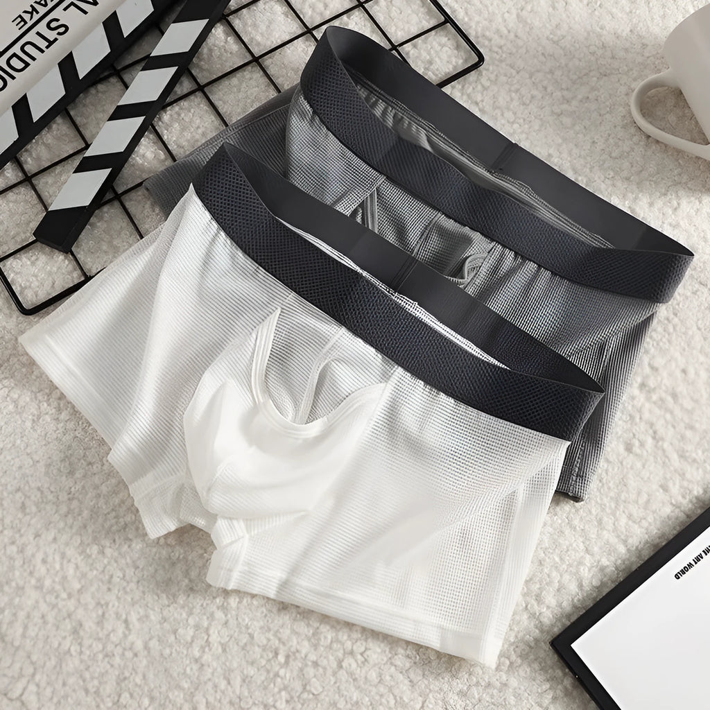 Men's solid colour Ice Silk nylon boxer underwear with mesh breathable fabric in black, grey, or white.