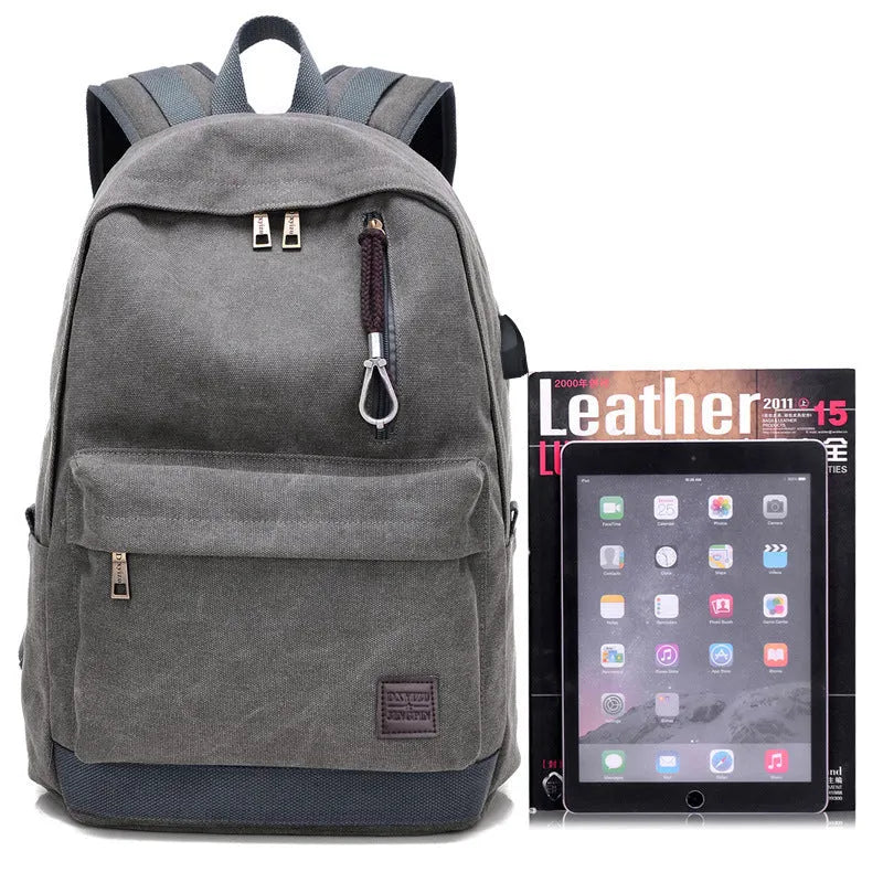 Canvas backpack in grey colour showing USB charging port, front zipper pocket, and adjustable shoulder straps