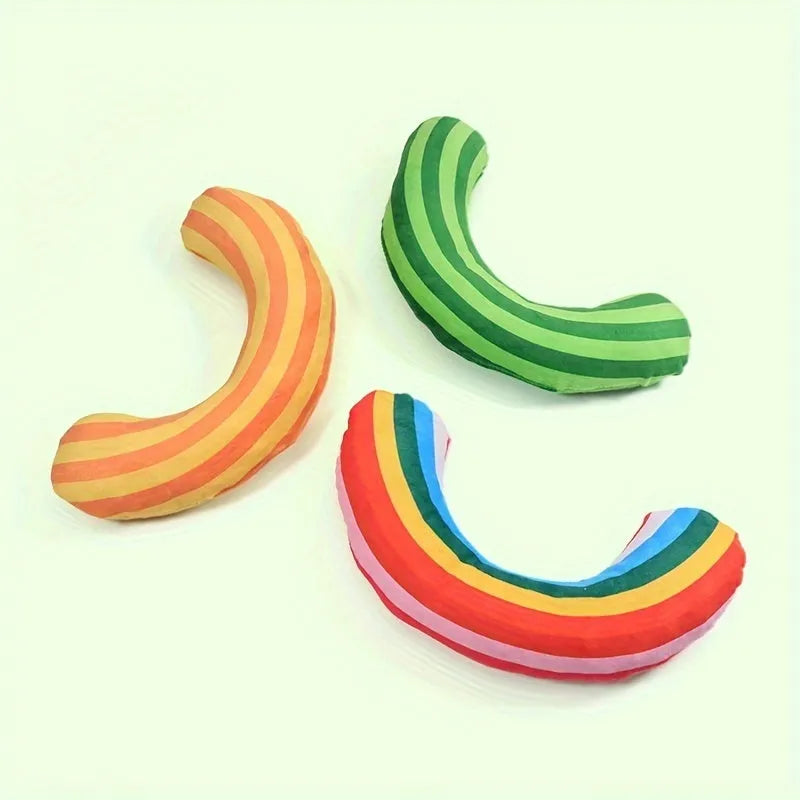 Green, rainbow, and yellow striped cat pillow and noise toy set on a white background
