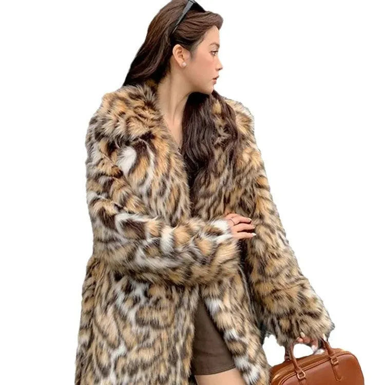 Long grey faux fur coat with a large fur collar and pockets on a model.