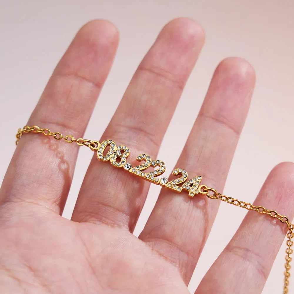 Stainless steel digital bracelet or necklace with diamond-set bezel showing time display, in gold, rose gold, or steel finish.