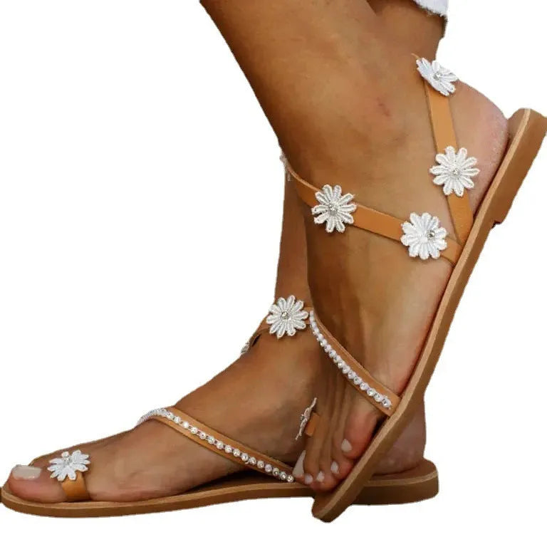 Brown women's Roman sandals with flat rubber soles, floral decoration, and herringbone toe shaping