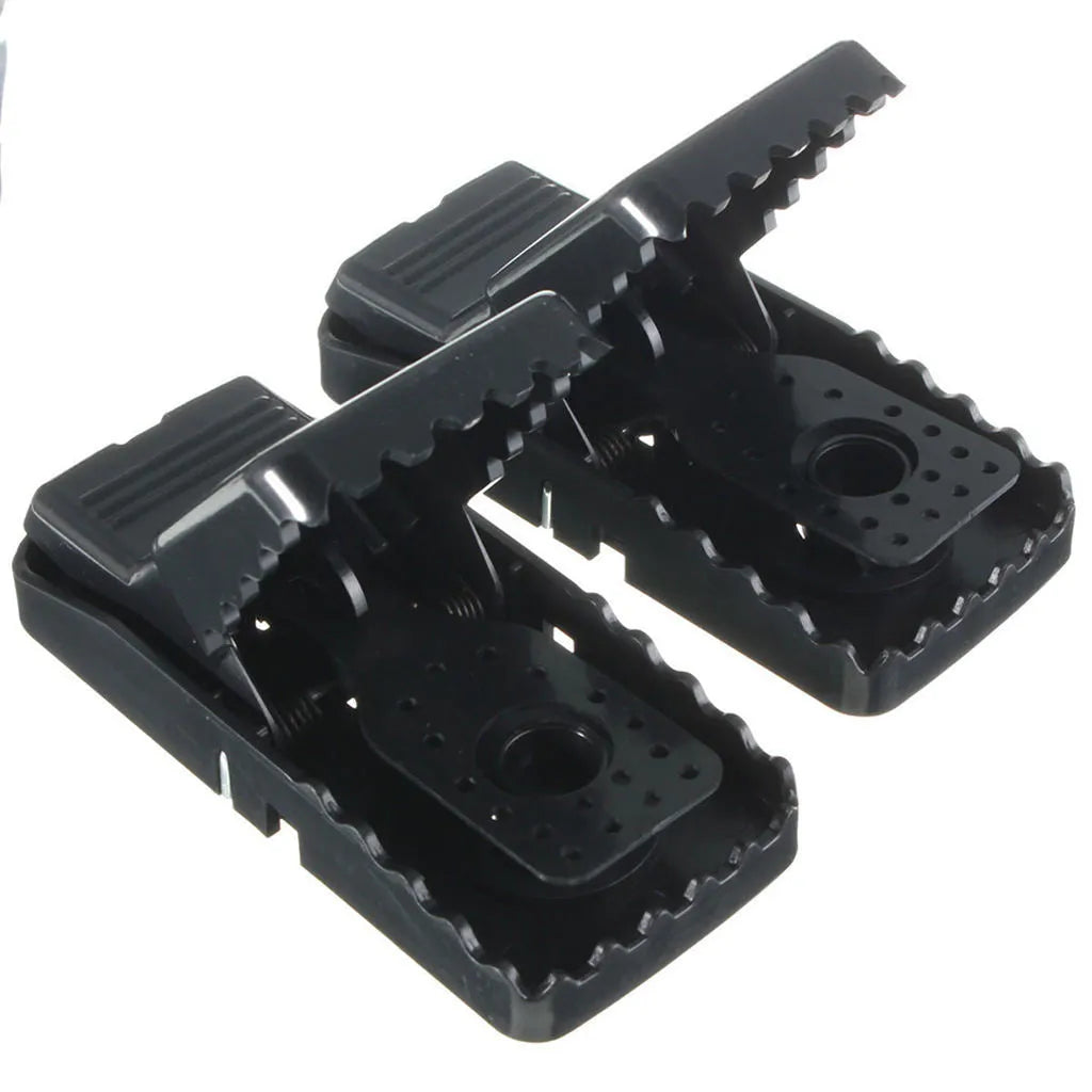 Six black plastic snapping mousetraps showing size and smooth surface.